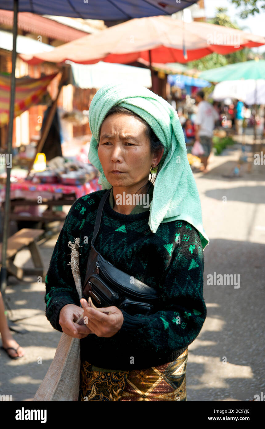 Une femme portant une coiffe serviette verte sortir shopping dans le marché de produits frais tous les jours de Luang Prabang, Laos Banque D'Images