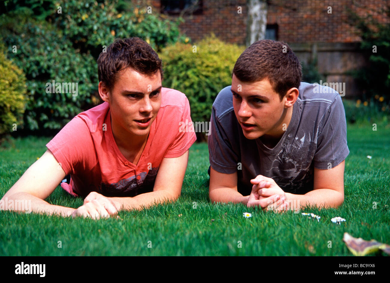 Les frères jumeaux non identiques dans leur jardin à la maison, dans le Kent en Angleterre, se détendre après les examens des étudiants sont plus Banque D'Images