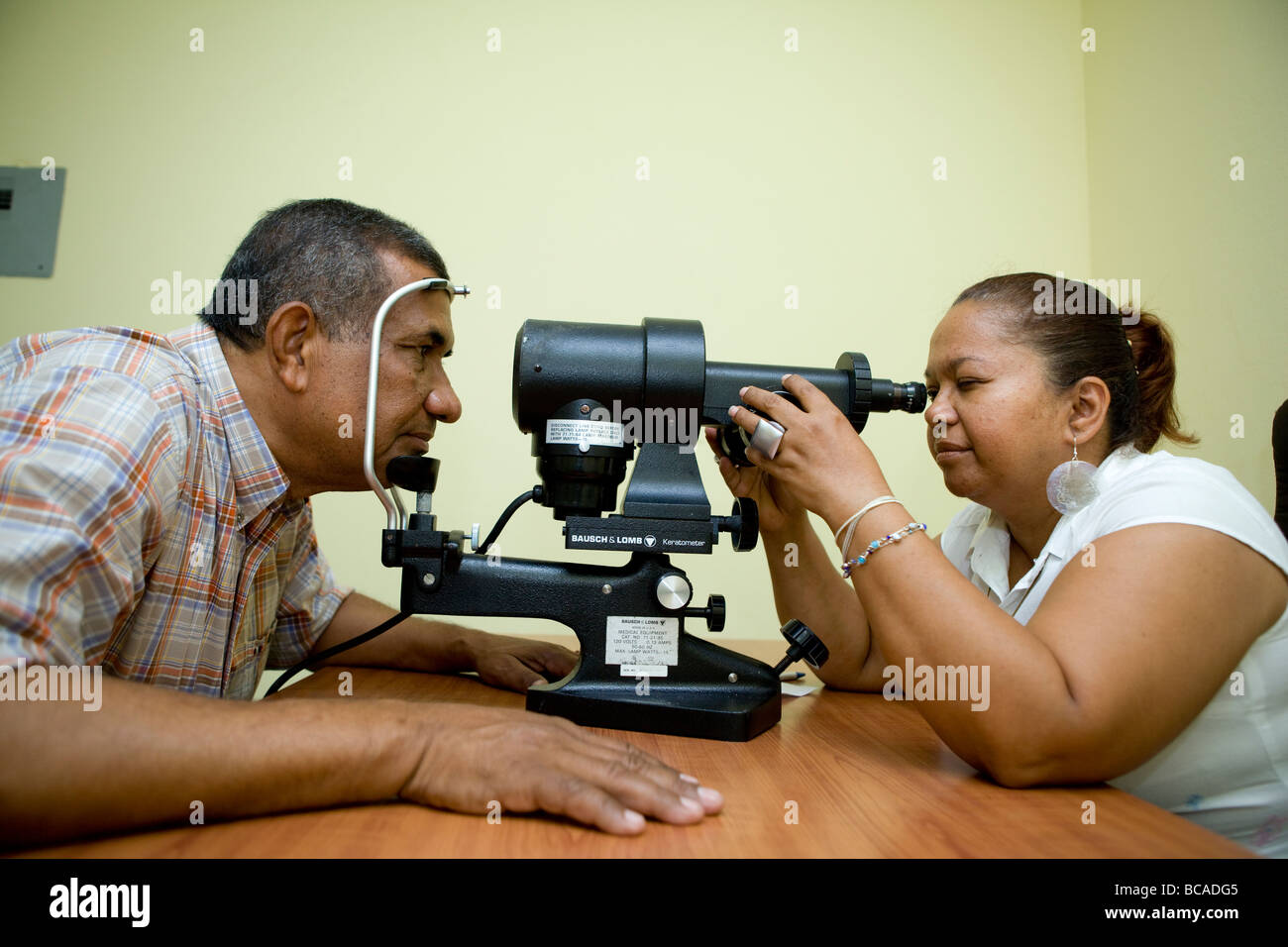Opticien donnant à l'homme tout un examen de la vue Banque D'Images