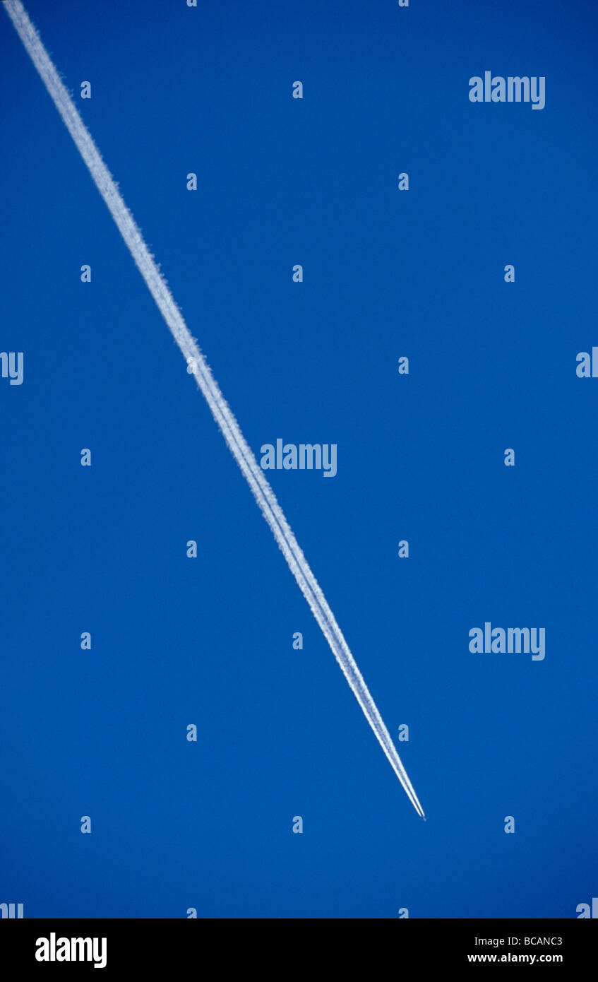 Un jumbo jet Airliner court de par un ciel bleu avec des traînées de vapeur. Banque D'Images