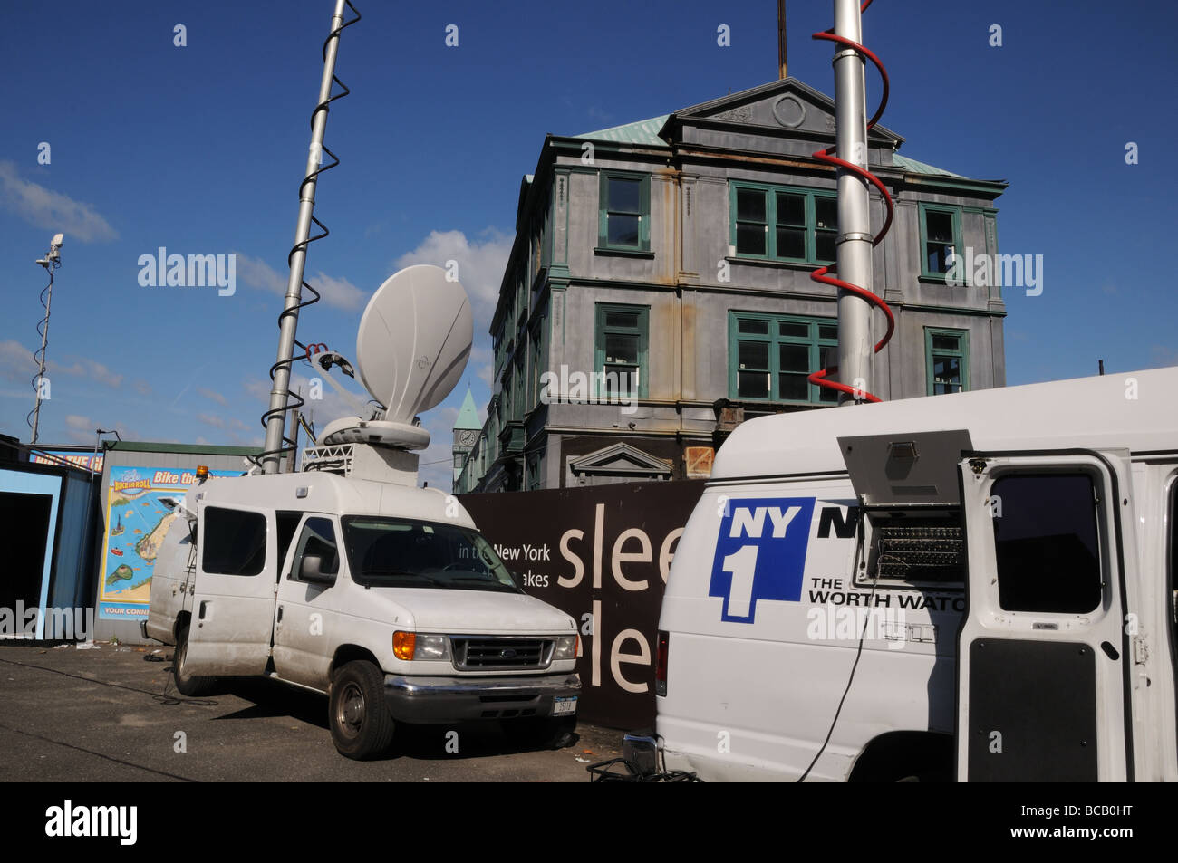 Camions émetteur de télévision signaler un reportage dans Battery Park à l'extrémité sud de Manhattan. Derrière eux est Pier A. Banque D'Images