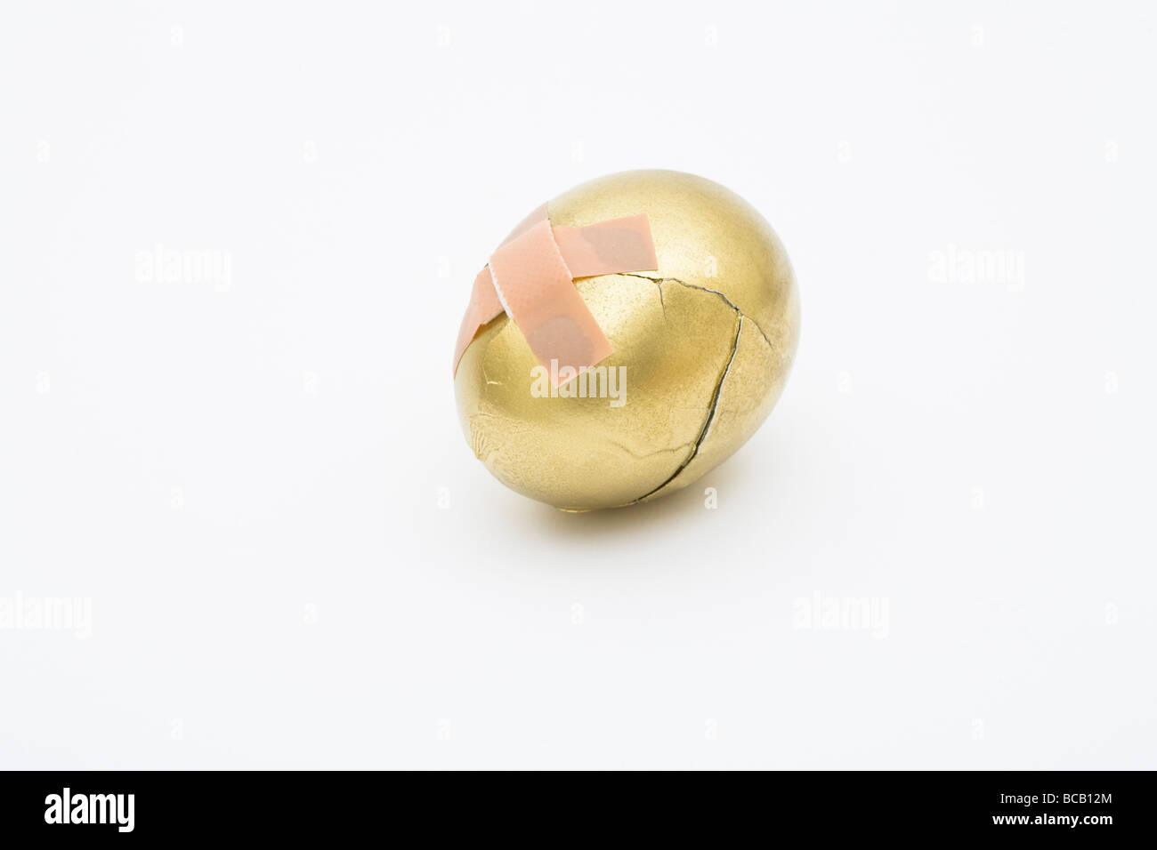 La rupture d'un œuf d'or modifié avec un plâtre Banque D'Images