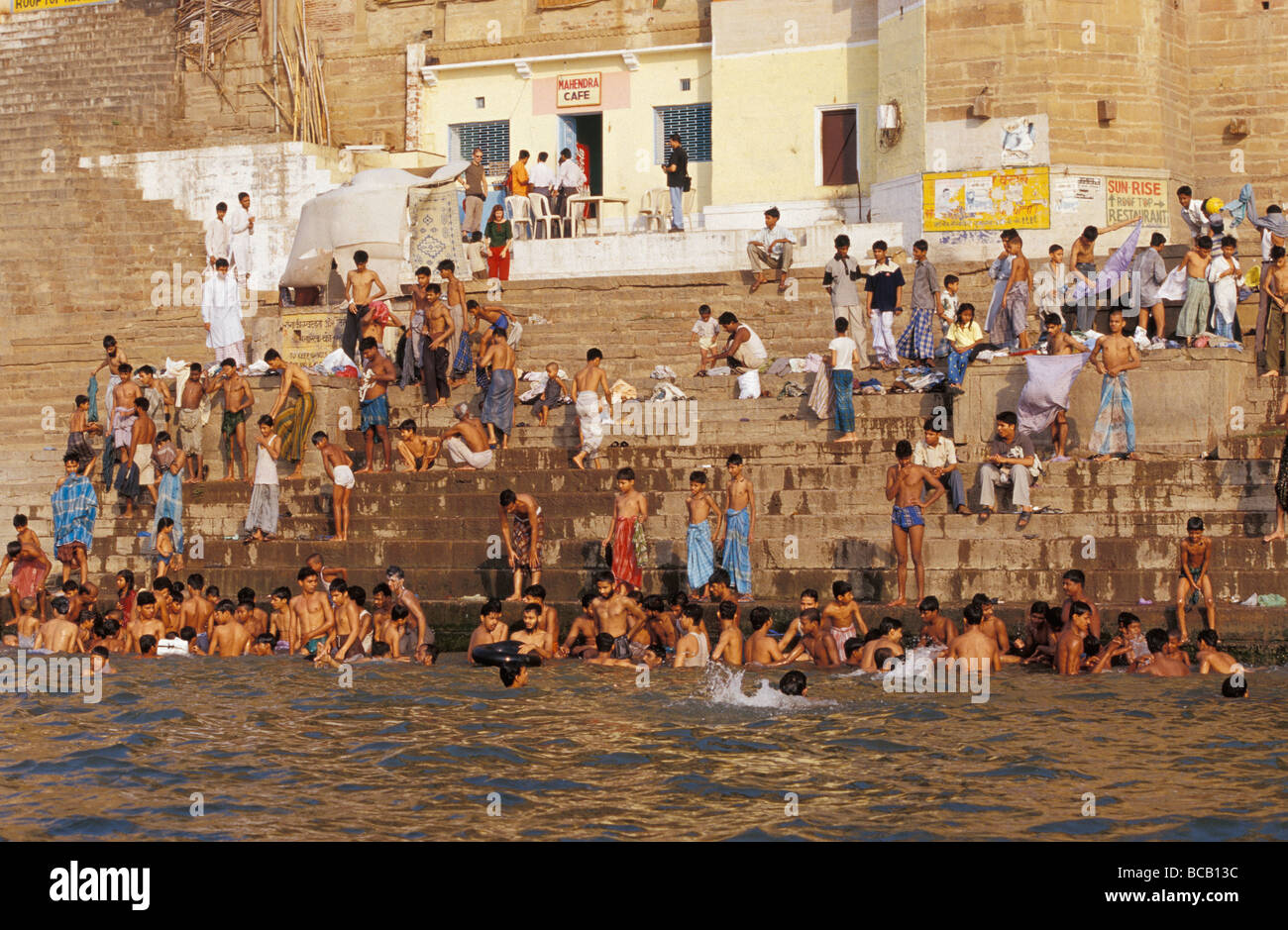 Les hommes et les garçons se baignent dans une ancienne ghat le long du Gange sacré. Banque D'Images