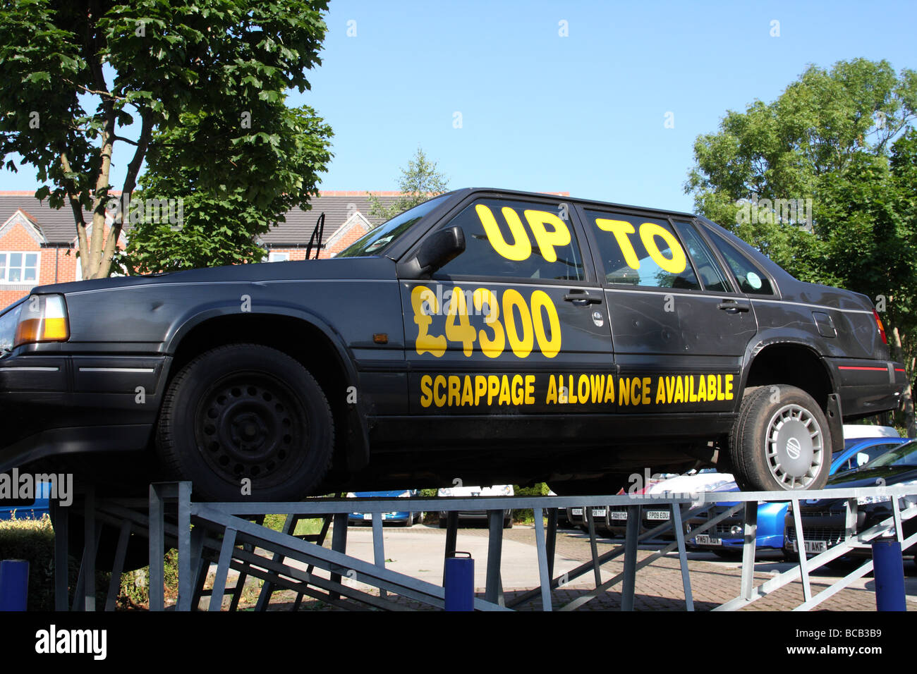 Une vieille voiture utilisée pour annoncer l'indemnité de mise à la ferraille dans une concession dans une ville du Royaume-Uni. Banque D'Images