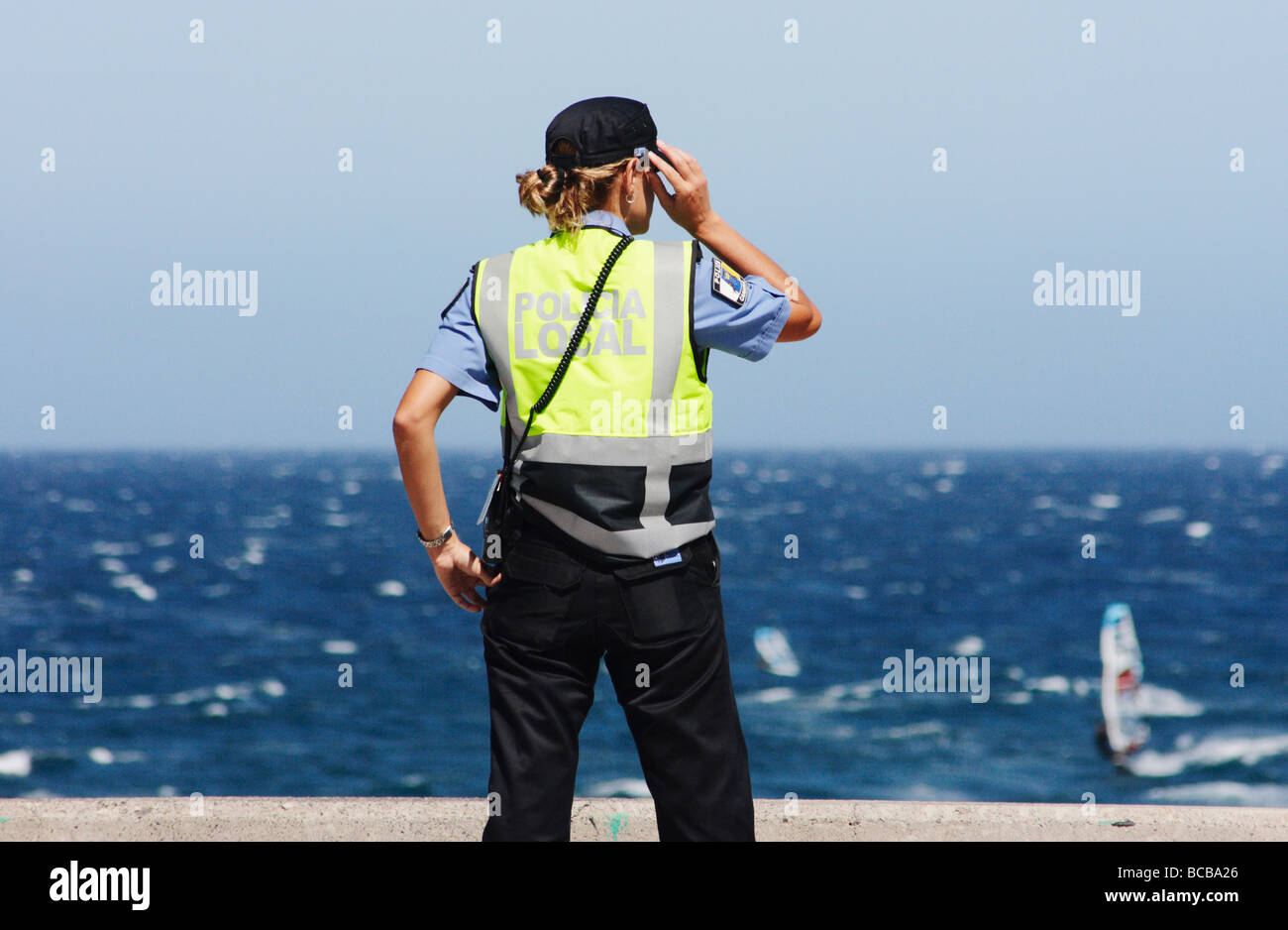 Policia Local (police locale) policewoman regardant la mer à Pozo sur Gran Canaria dans les îles Canaries, Espagne Banque D'Images
