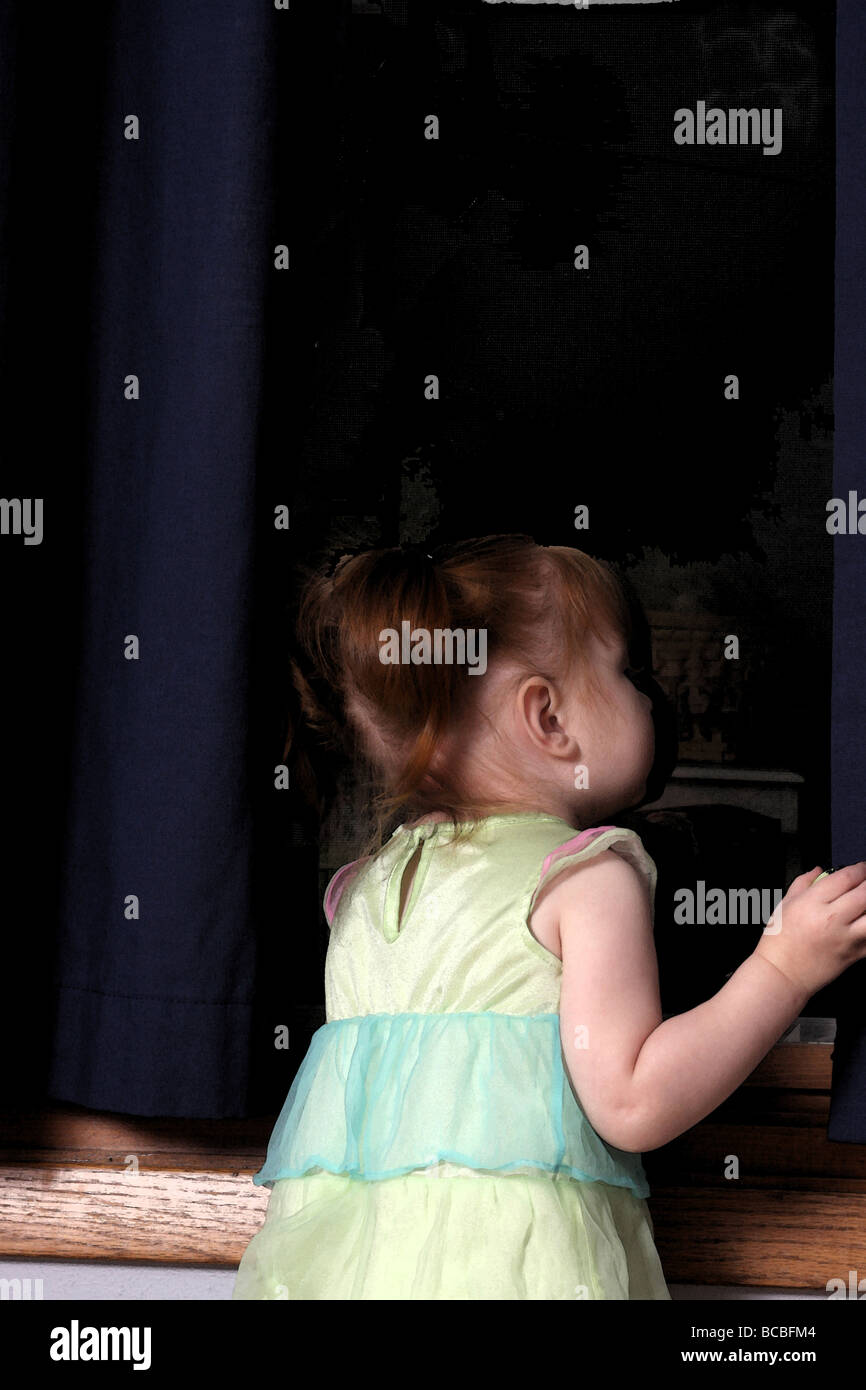 Une jeune fille, la fenêtre de sa chambre à coucher la nuit Banque D'Images