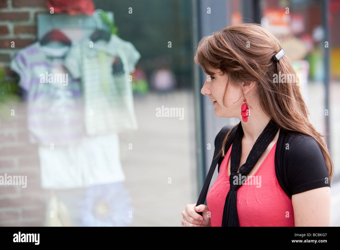 Jeune brunette attrayant à la recherche dans les fenêtres Banque D'Images