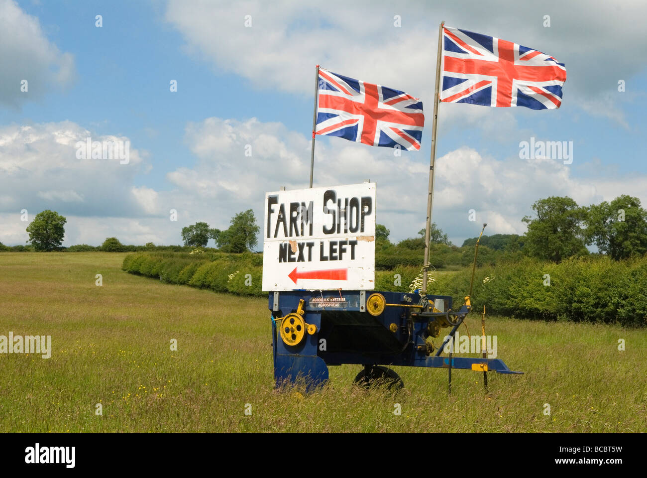 Panneau de magasin de ferme érigé dans un champ, tournez à gauche suivant avec les drapeaux Union Jack flottant. Campagne rurale anglaise Leicestershire Angleterre des années 2009 2000 Royaume-Uni Banque D'Images