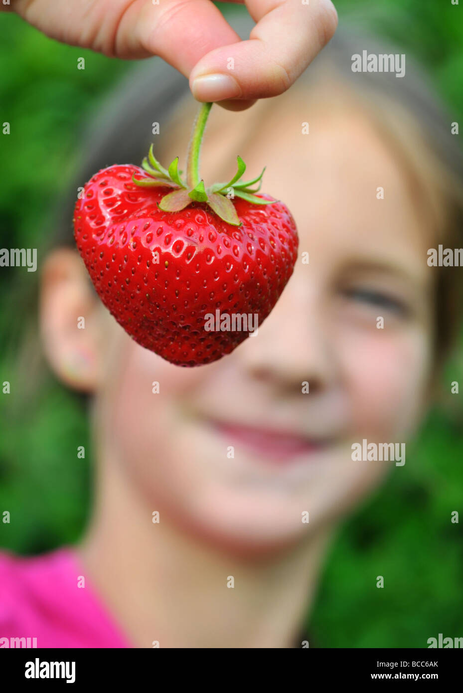 Fraise, fraises, enfant tenant une fraise Banque D'Images