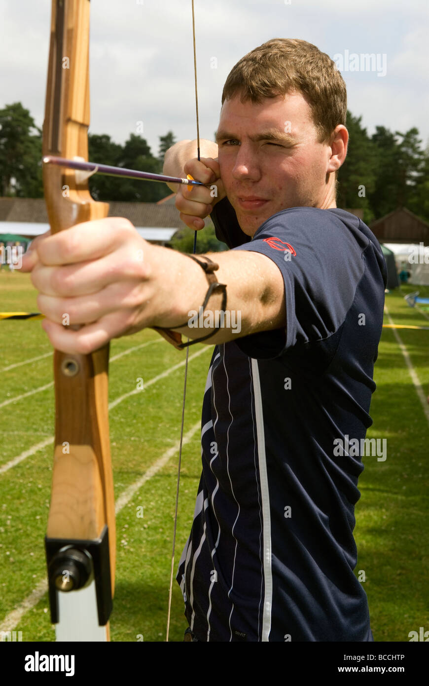 21 ans, homme, et d'essayer au tir à un été fayre dans Blackmoor, près de Bordon, Hampshire, Royaume-Uni. Banque D'Images