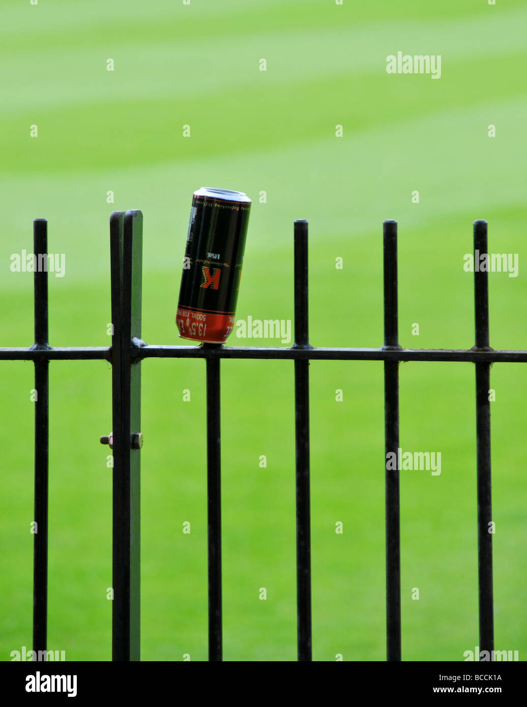 La bière peut jeter sur fence Banque D'Images