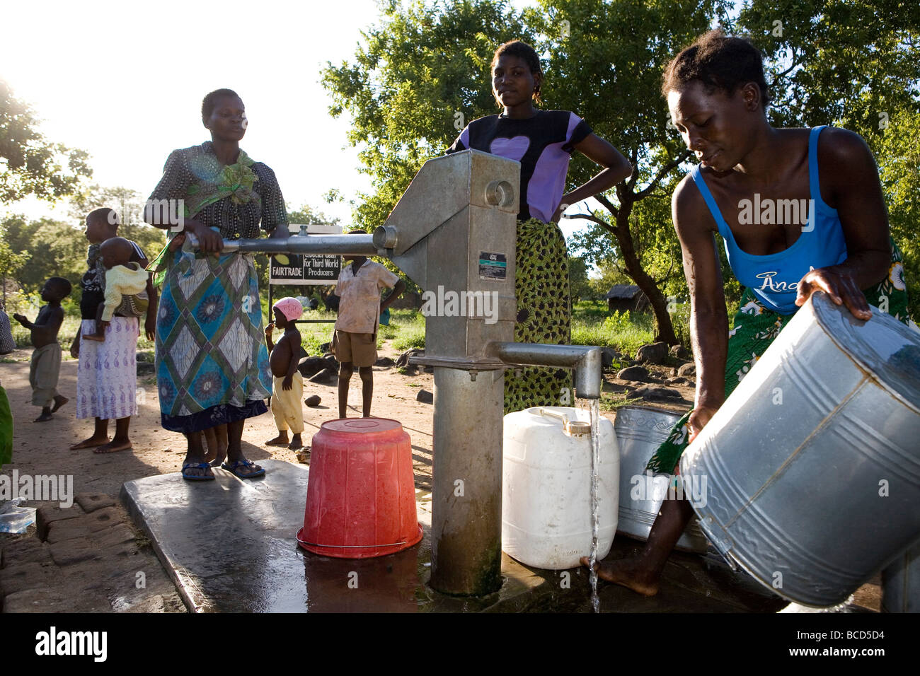 La collecte de l'eau de la famille au point d'eau Banque D'Images