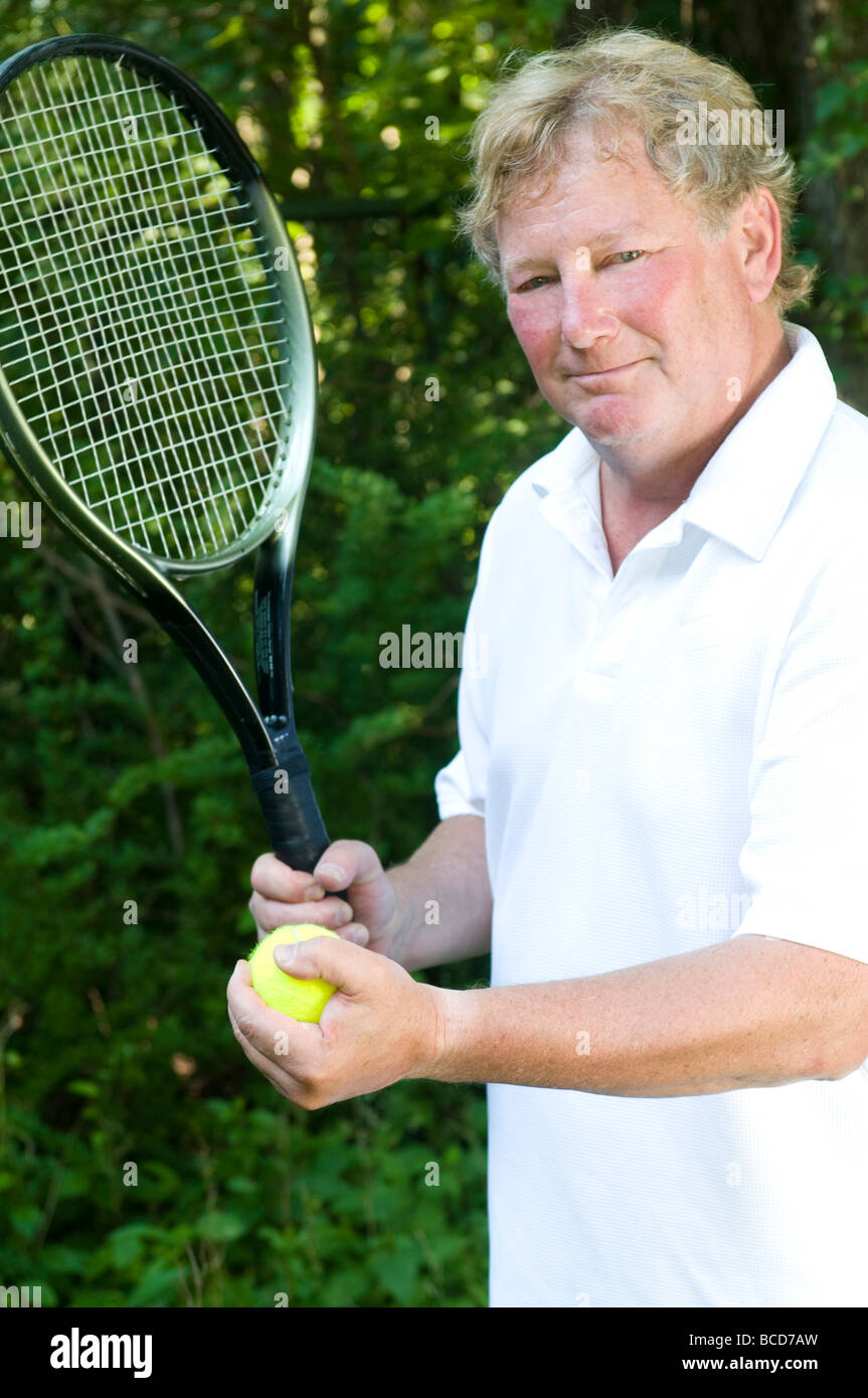 L'âge moyen des hauts bel homme tennis tennis player démontrant sa course en raquette et balle Banque D'Images