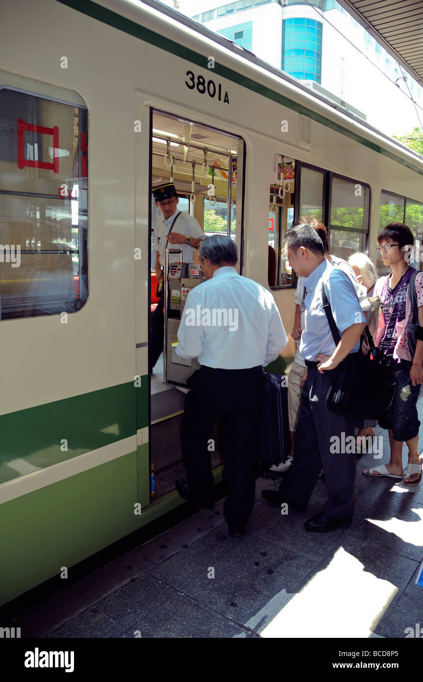 Les japonais de monter dans un train, Hiroshima, Japon Banque D'Images