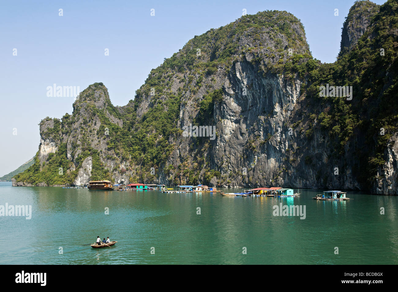 Fishermens village flottant ci-dessous certains des 3000 îles karstiques de calcaire dans la baie d'Halong Une merveille naturelle du patrimoine mondial Banque D'Images