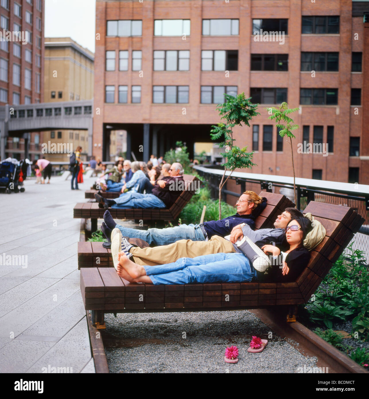 Les personnes se détendant dehors sur une chaise longue en bois Ipe salon fauteuil inclinable meubles sur le High Line Park Garden à New York City NYC America KATHY DEWITT Banque D'Images