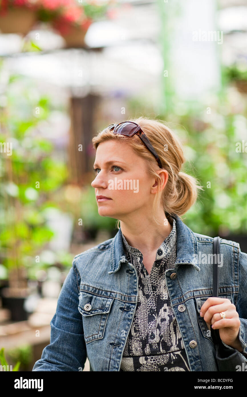 Portrait, femme blonde dans une serre. Banque D'Images