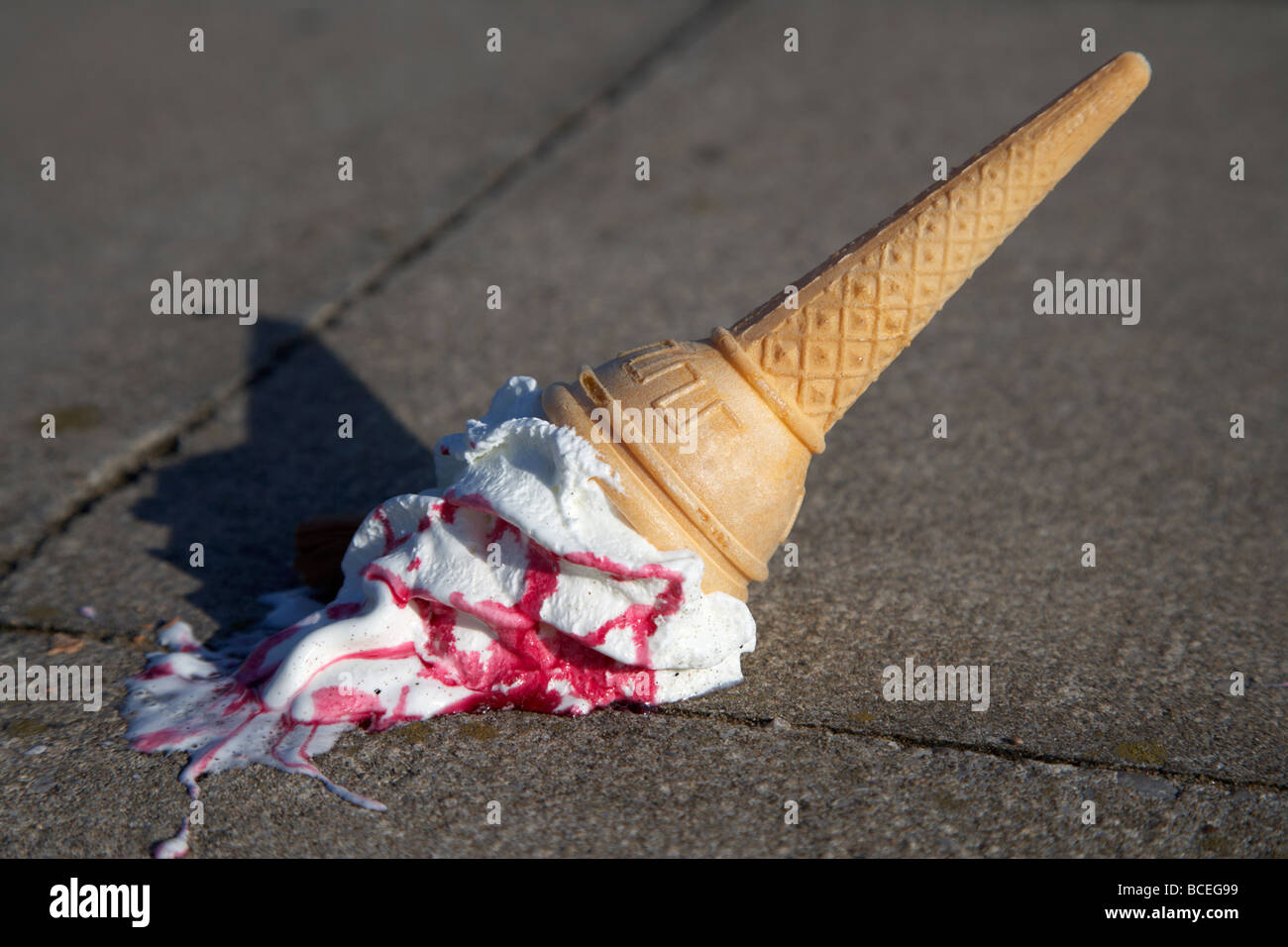 Melting ice cream cone déposé sur une chaussée ou jetés à la masse dans le uk Banque D'Images