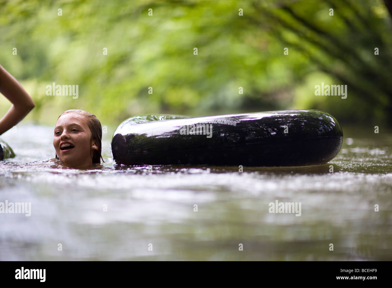 Les adolescents s'amusant dans innertubes dans l'eau Banque D'Images