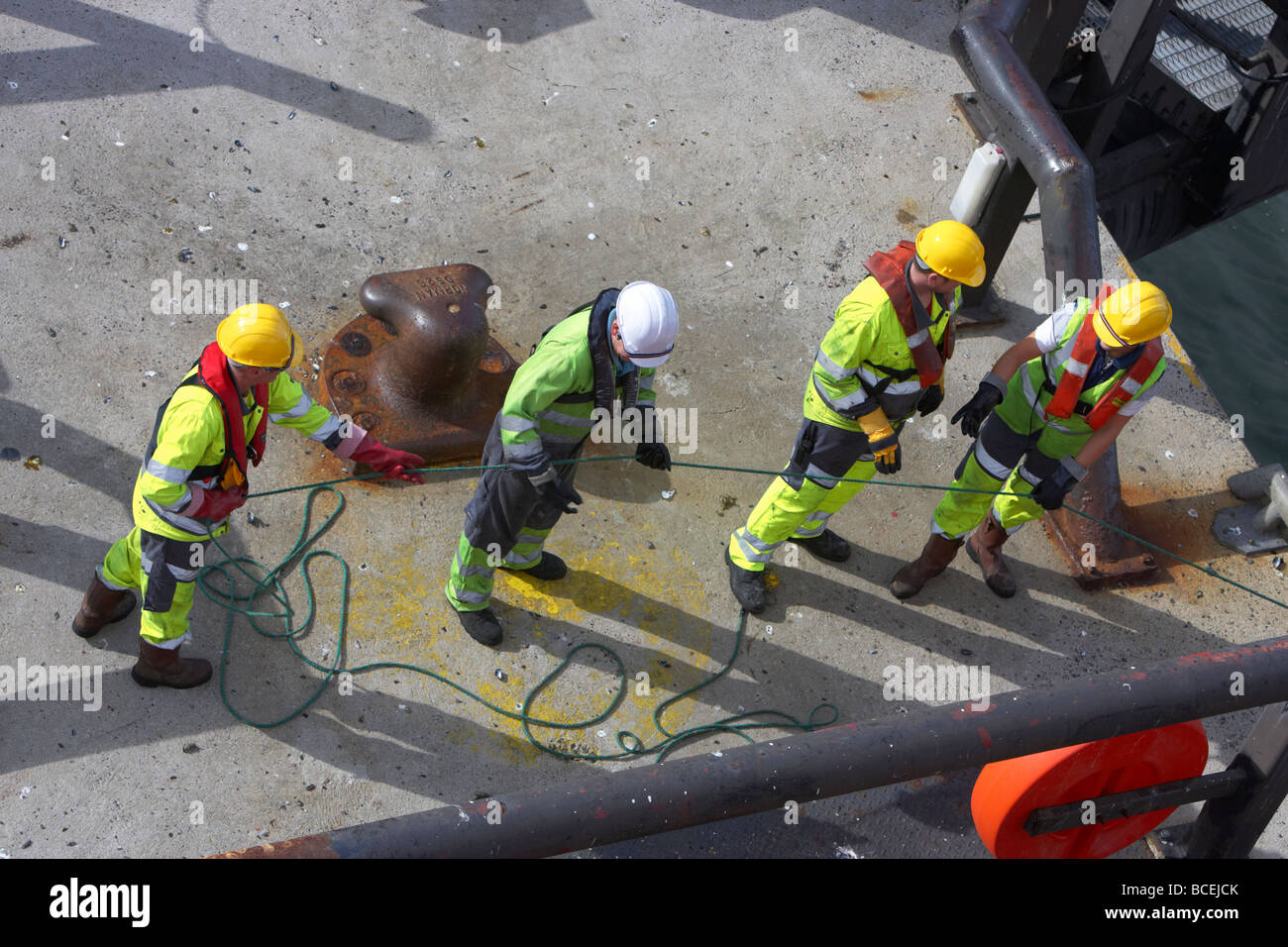 Shore crew tirer la ligne de sécurité relié à la corde de bateau dans quay tout en mouillage dans le port de Belfast, Irlande du Nord uk Banque D'Images