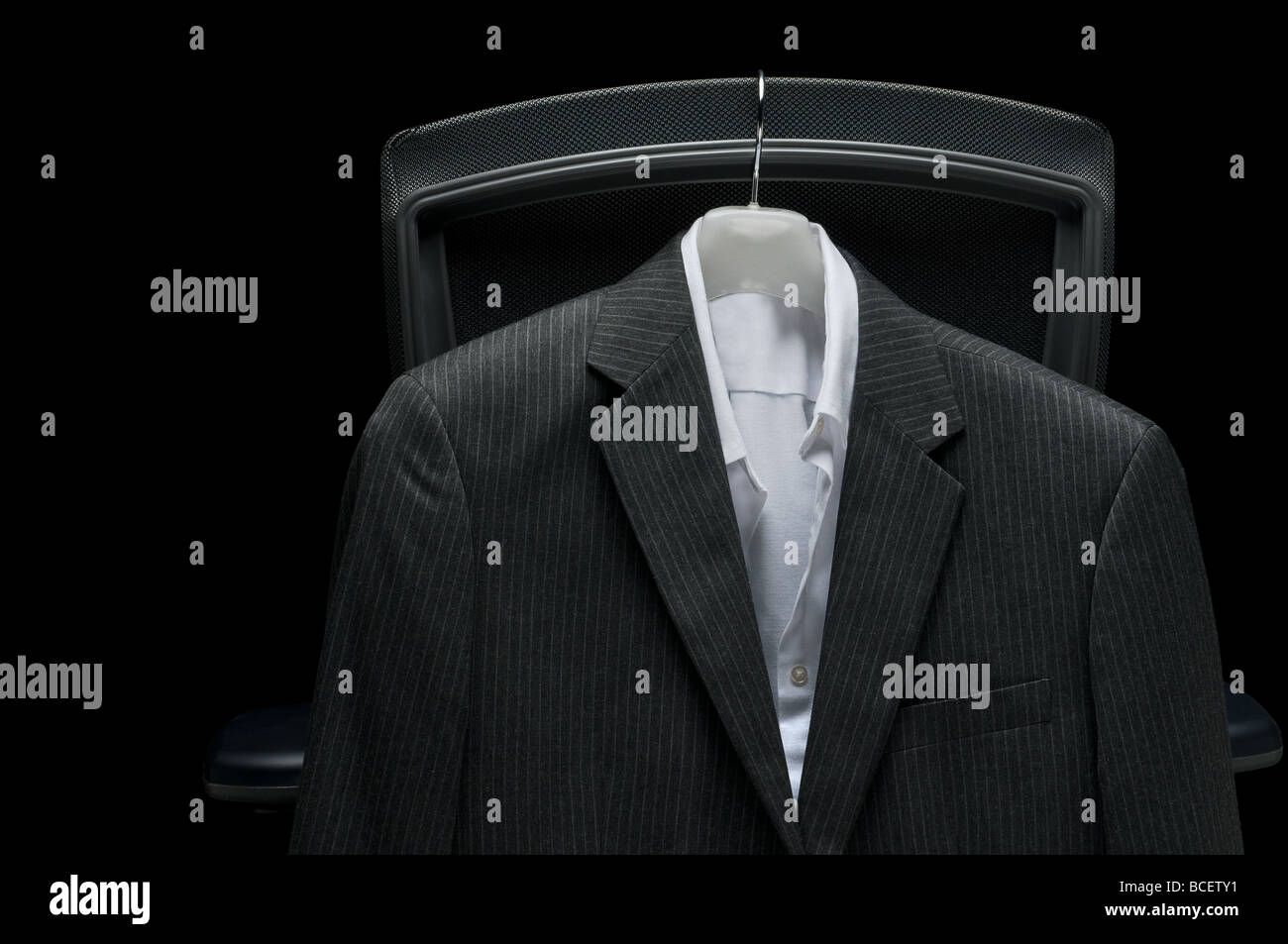 Chemise blanche et veste d'affaires accroché sur une chaise Banque D'Images