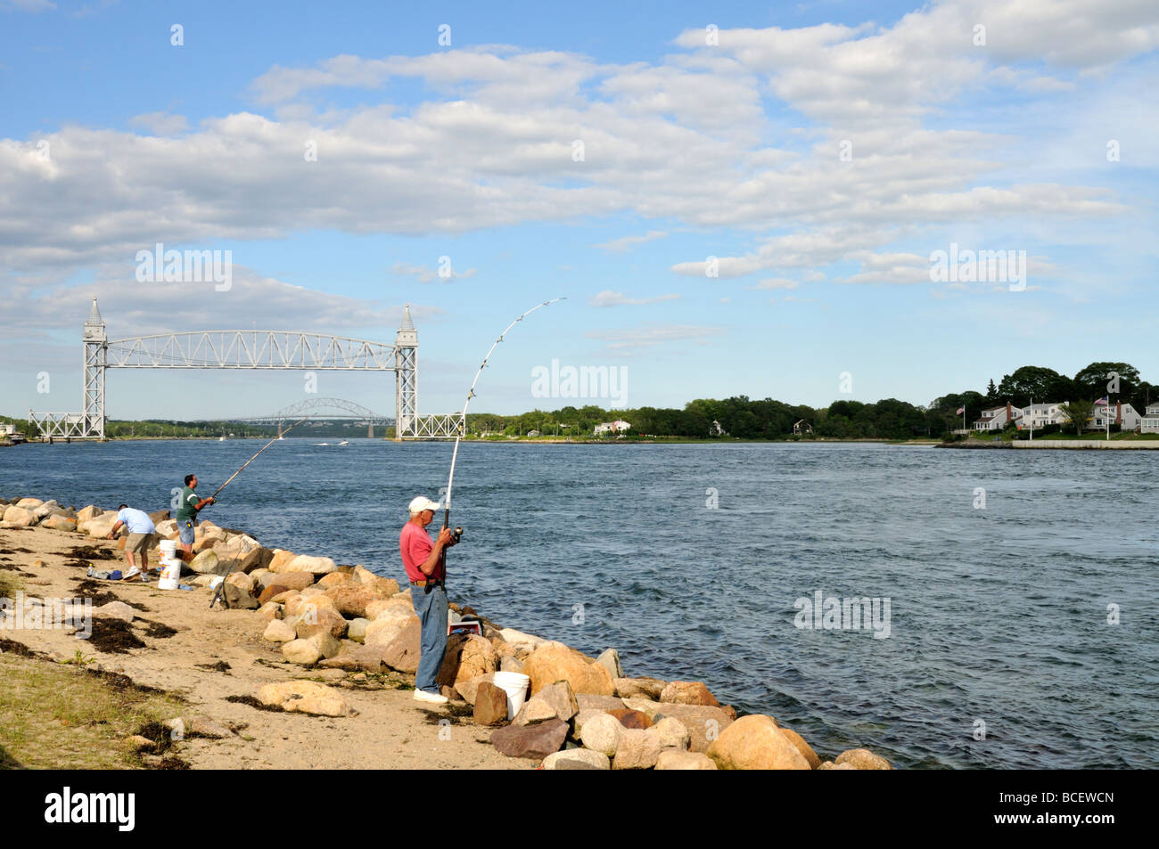 Les hommes la pêche sur les rives de Cape Cod Canal avec Railroad et ponts Bourne Cape Cod, Massachusetts USA Banque D'Images