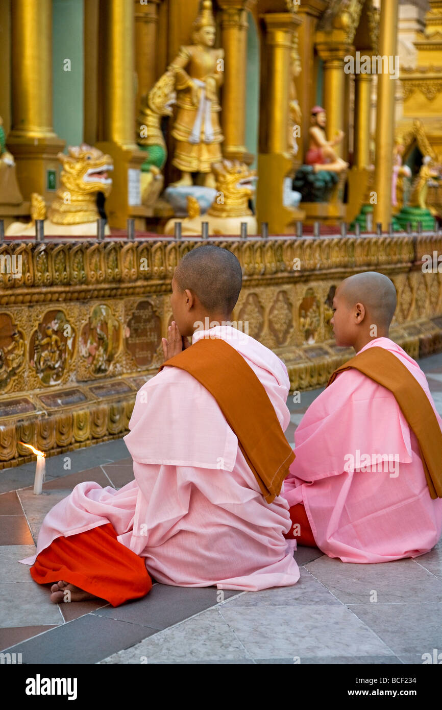 Le Myanmar, Birmanie, Yangon. Deux jeunes nonnes bouddhistes prier à la pagode Shwedagon Golden Temple complexe. Banque D'Images