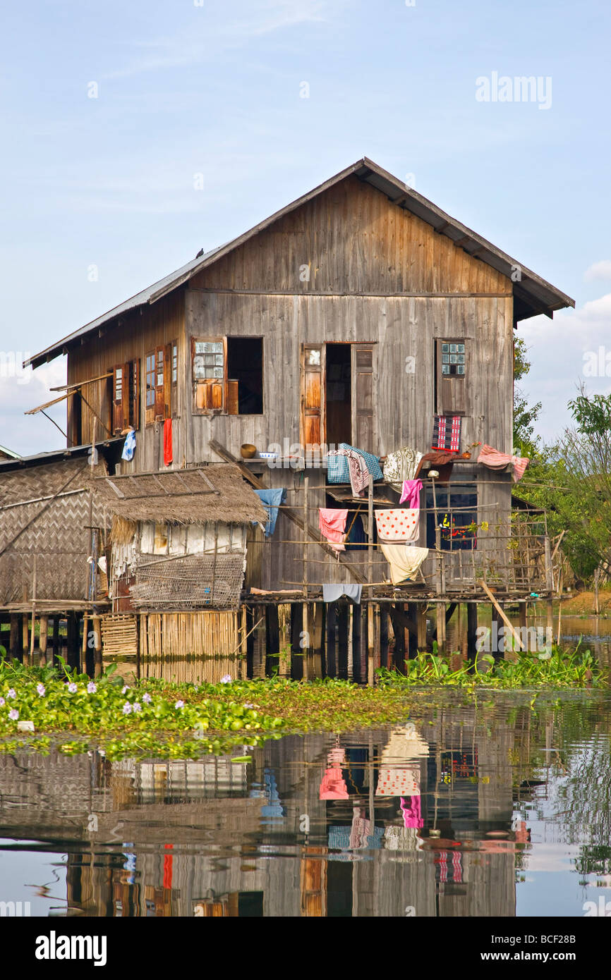 Le Myanmar, Birmanie, le lac Inle. Une ethnie Intha typique maison en bois sur pilotis dans le lac Inle, pittoresquement abritée par les montagnes. Banque D'Images