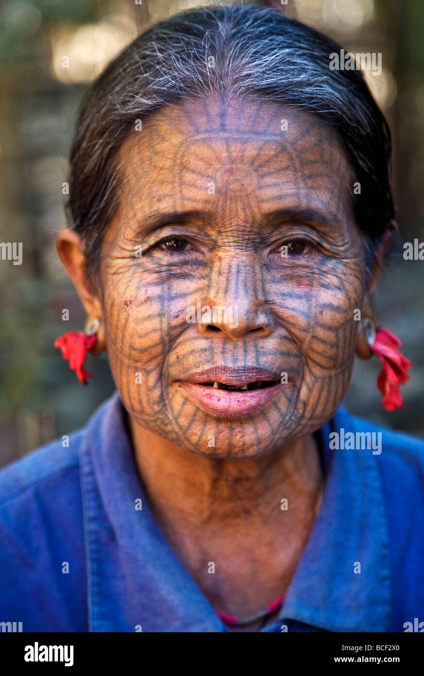 Le Myanmar, l'État de Chin, Kyi Chaung Village. Une femme tatouée Chin avec visage et de la bouche rouge vitrail dû à mâcher de ponderosa l'écrou. Banque D'Images