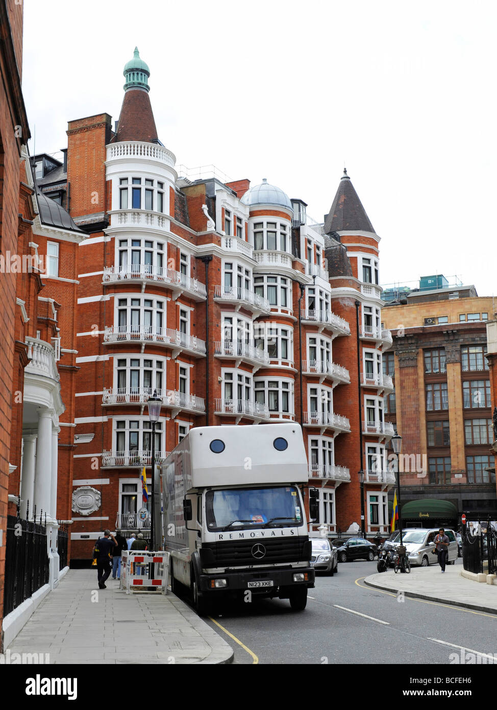 Les absorptions van à l'extérieur d'un bloc d'appartements luxueux hôtel particulier à Knightsbridge avec Harrods store dans l'arrière-plan Banque D'Images