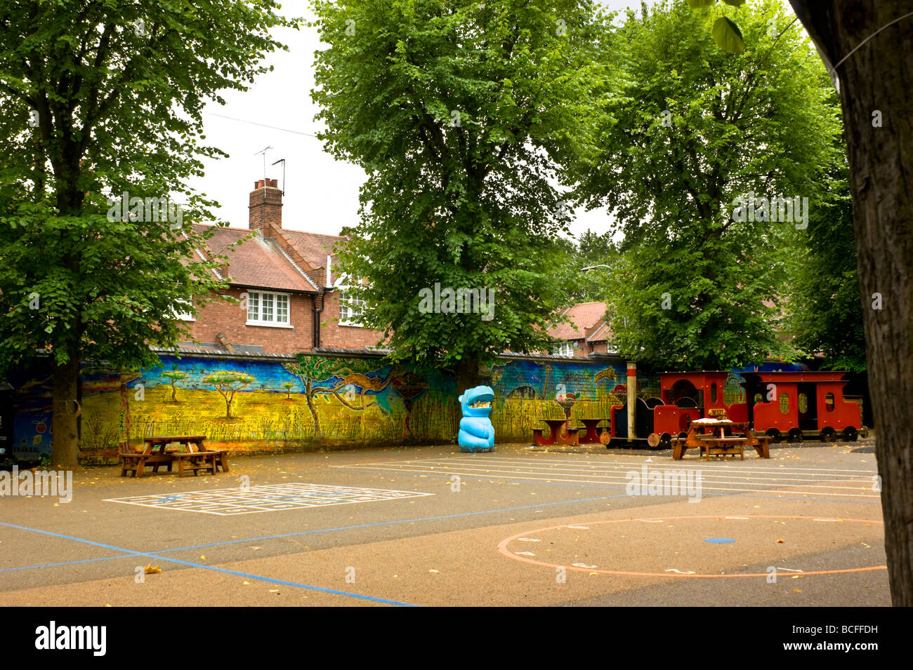Murale colorée dans une étape clé 1 jeux pour enfants en école primaire dans le nord de Londres Angleterre Royaume-uni - avec hippo bin et jouer train Banque D'Images