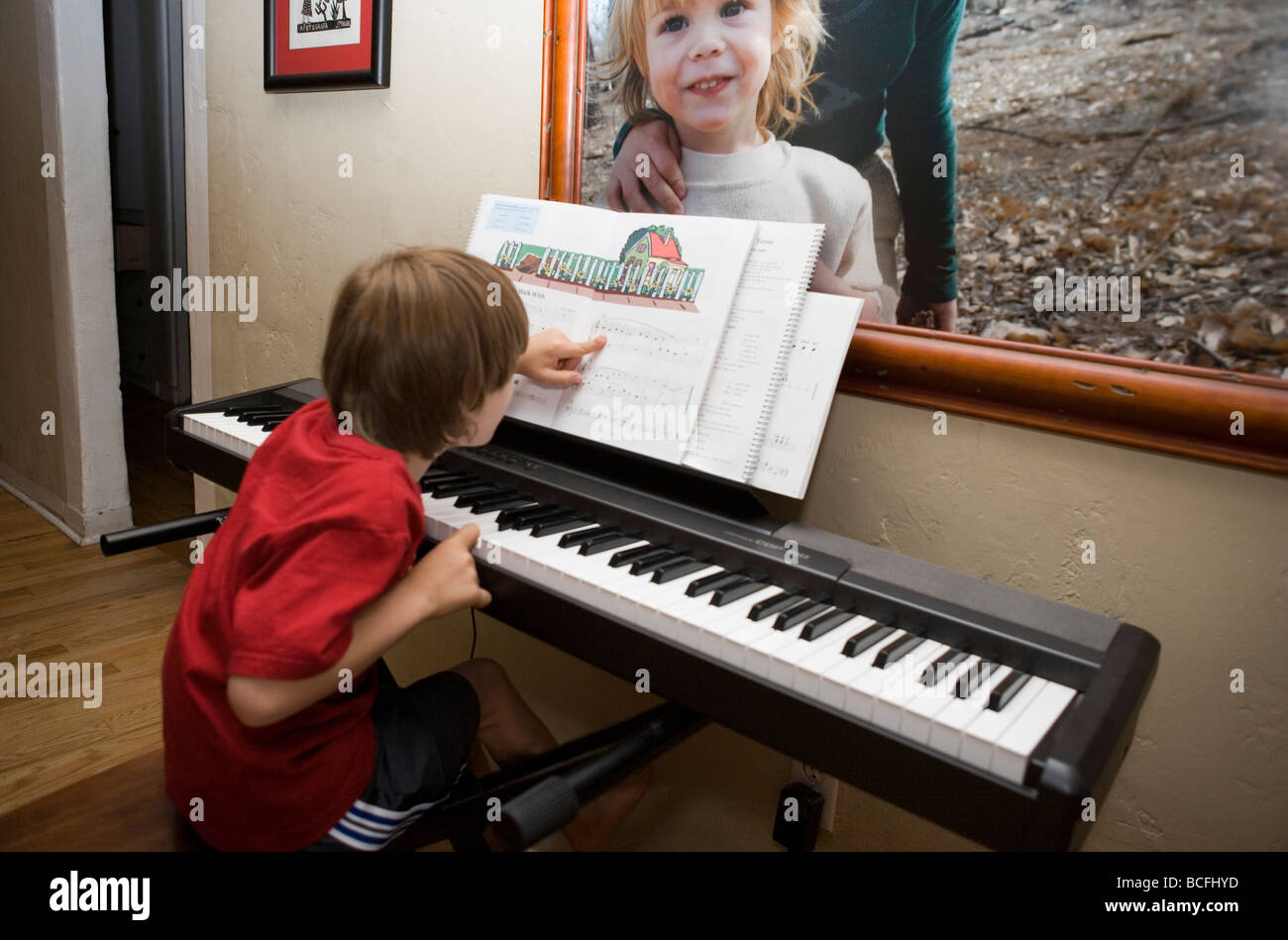 Sept ans la pratique de piano à la maison, apprendre à lire les notes de  musique dans son livre Photo Stock - Alamy