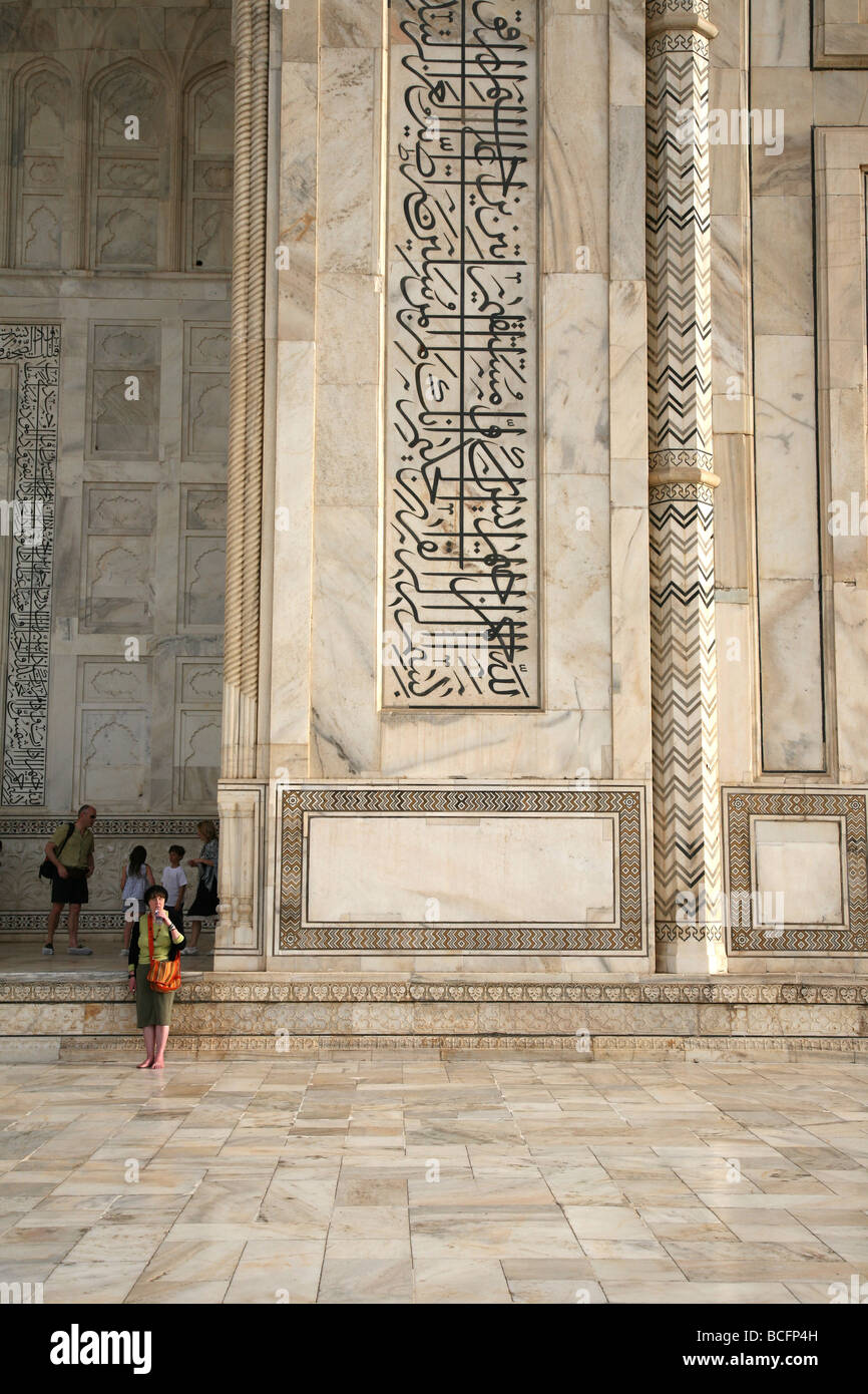 Détail des scripts incrustée dans le marbre blanc autour du Taj Mahal Agra avec touristes inclus pour l'échelle Banque D'Images