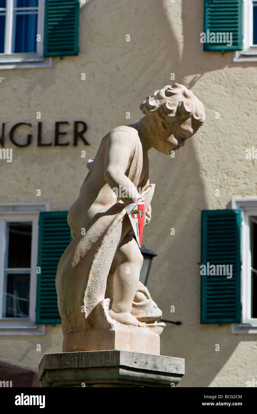 Statue de pierre d'un garçon et de poisson sur la place de la ville de Zell am See en Autriche. Banque D'Images