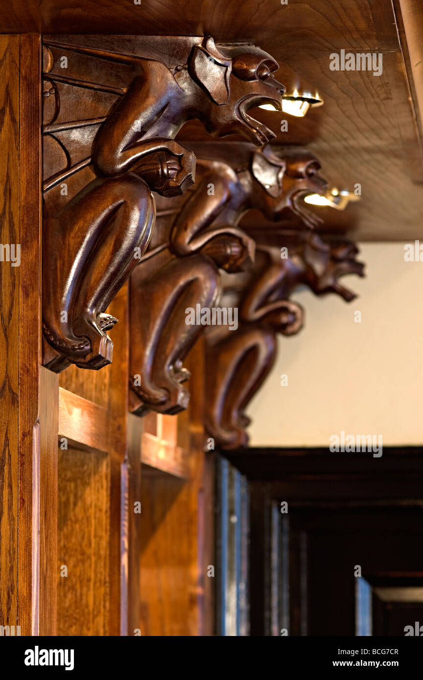 Supports en bois sculpté dans un pub sur les étagères et sculpté en forme de gargouilles comme décoration pub Banque D'Images