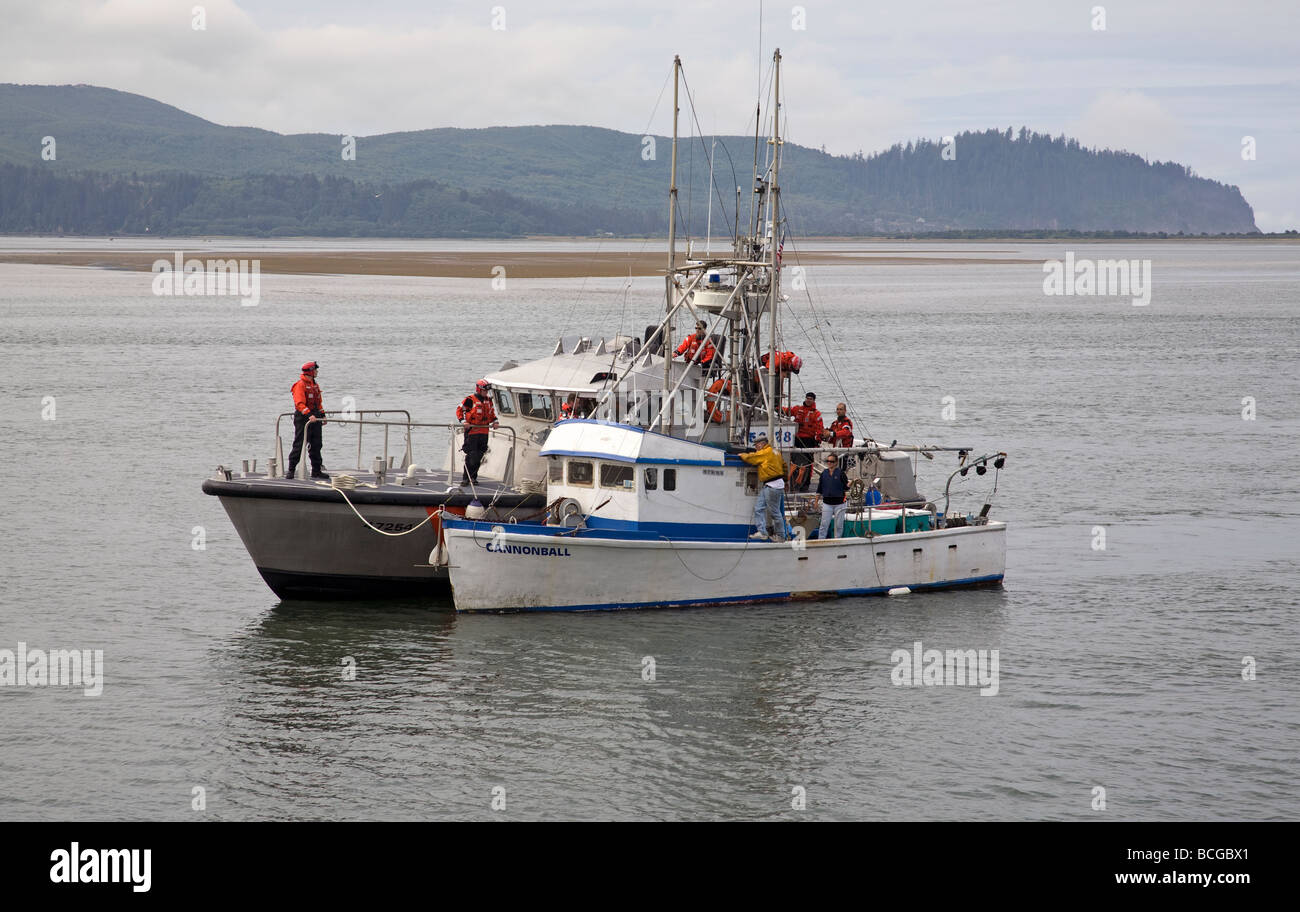 Un garde-côte porte secours à un bateau de pêche en Baie Tillamook près de la ville de Garibaldi sur la côte du Pacifique de l'Oregon Banque D'Images Un garde-côte porte secours à un bateau de pêche en Baie Tillamook près de la ville de Garibaldi sur la côte du Pacifique de l'Oregon Banque D'Images
