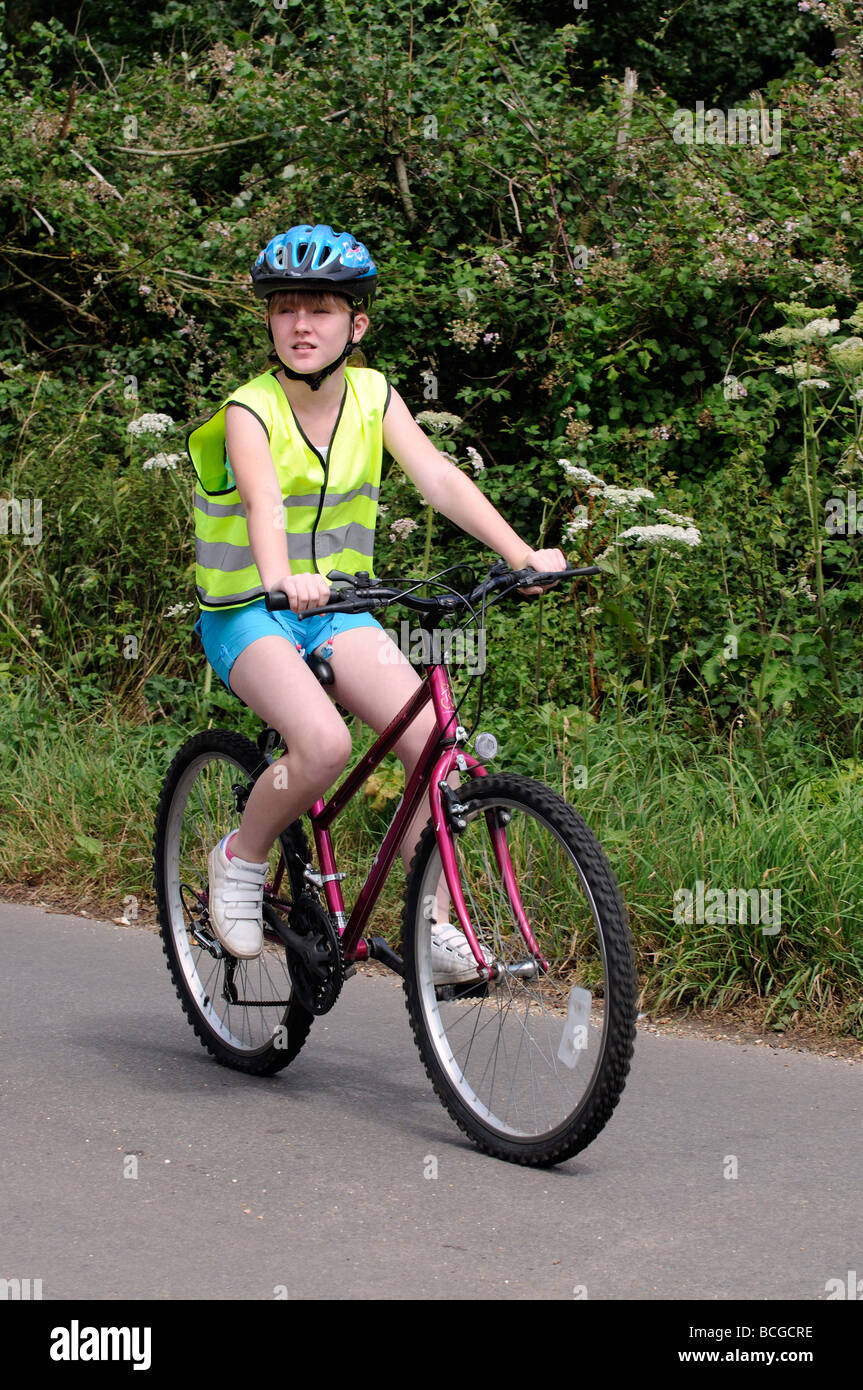 Enfant portant un gilet de sécurité réfléchissant et le casque de vélo sur  une route de campagne Photo Stock - Alamy