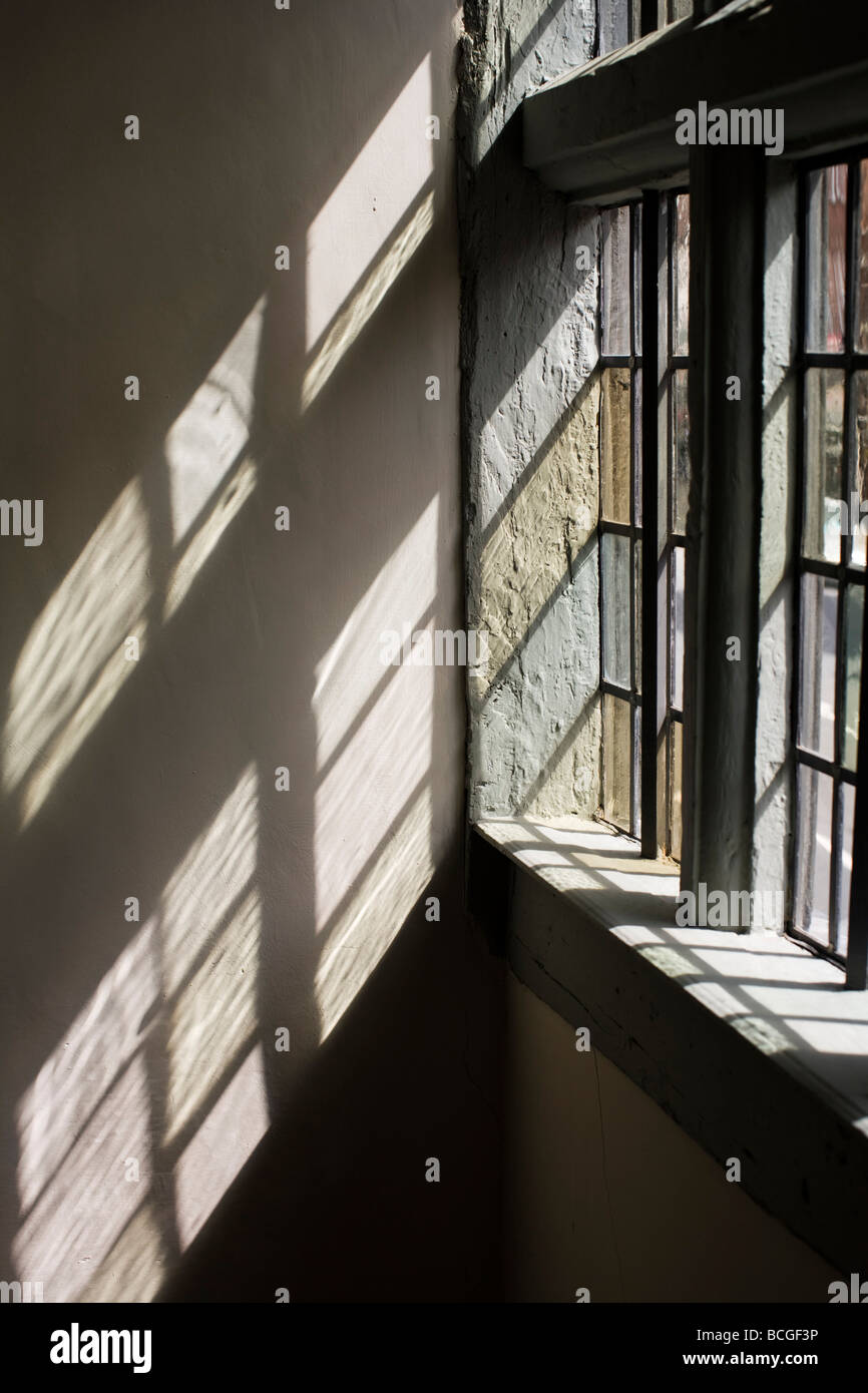 La lumière du soleil tombe à travers une fenêtre de verre au plomb Tudor dans la fenêtre 'hors de la hat' Centre, Tewkesbury Banque D'Images