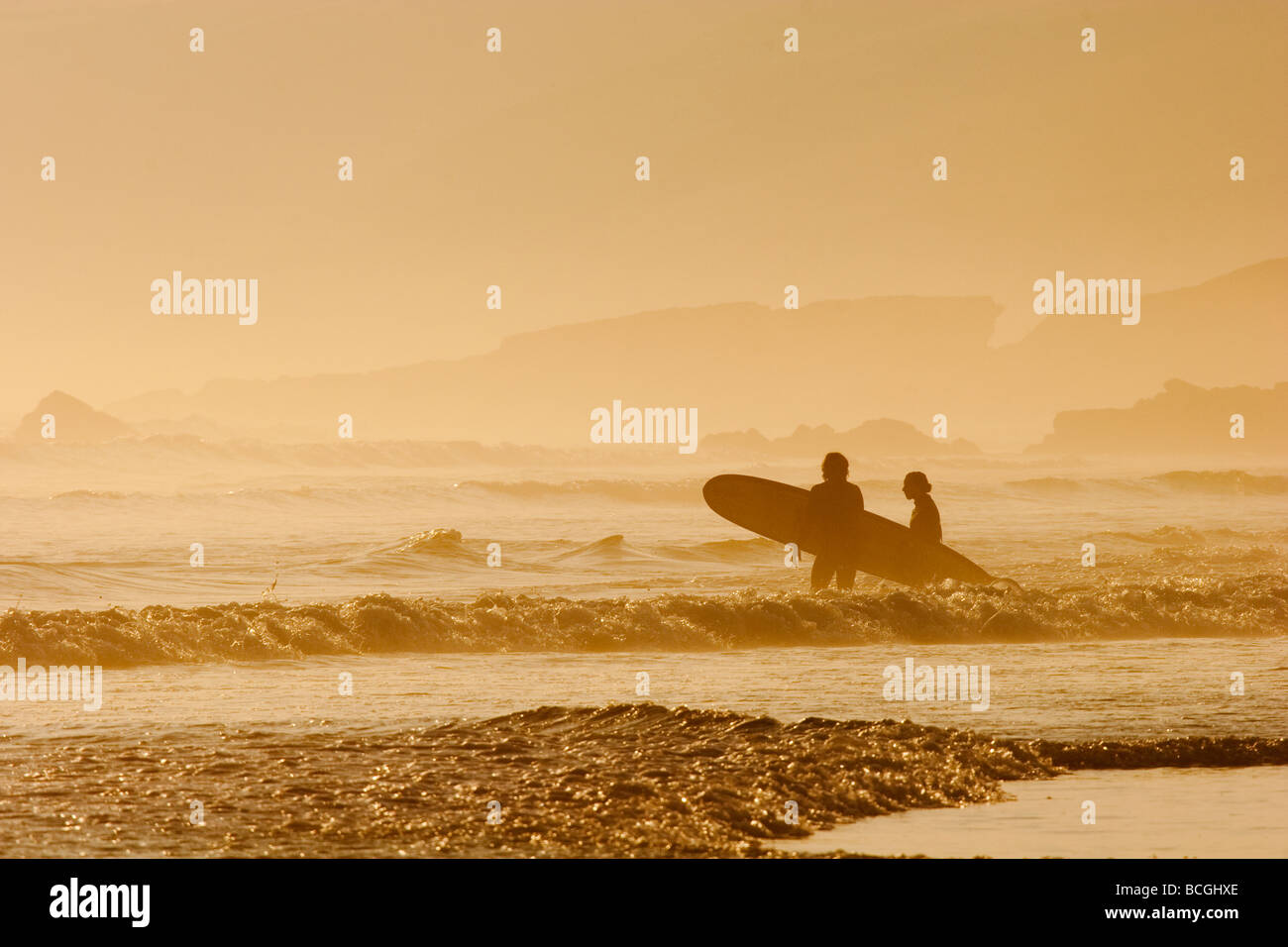 Le soleil se couche. Rouler dans le brouillard de la mer. Surfers off pour attraper la dernière vague de la soirée. Surf à Cornwall. Banque D'Images