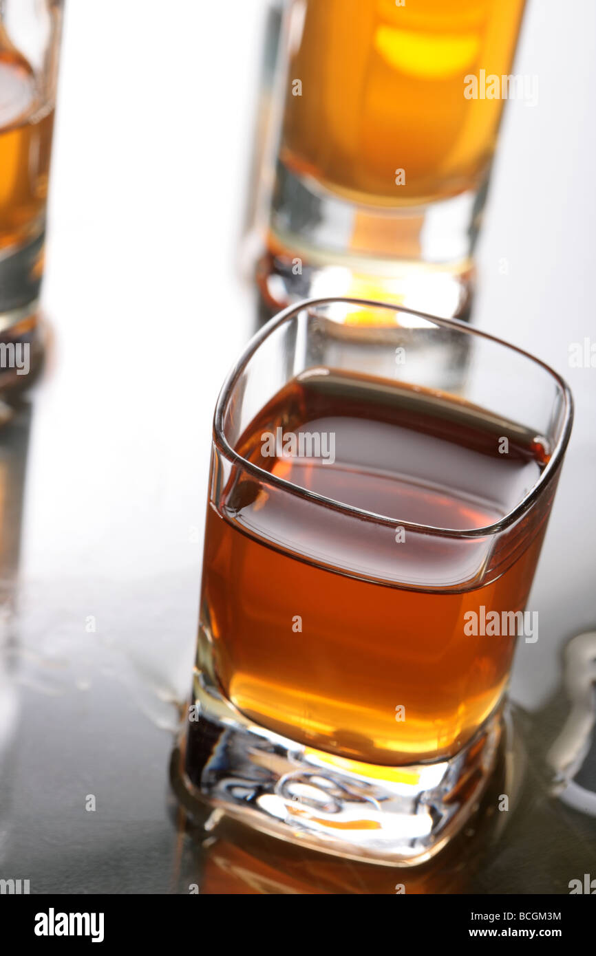 Un verre plein de whisky avec d'autres verres DOF peu profondes à l'arrière-plan Banque D'Images