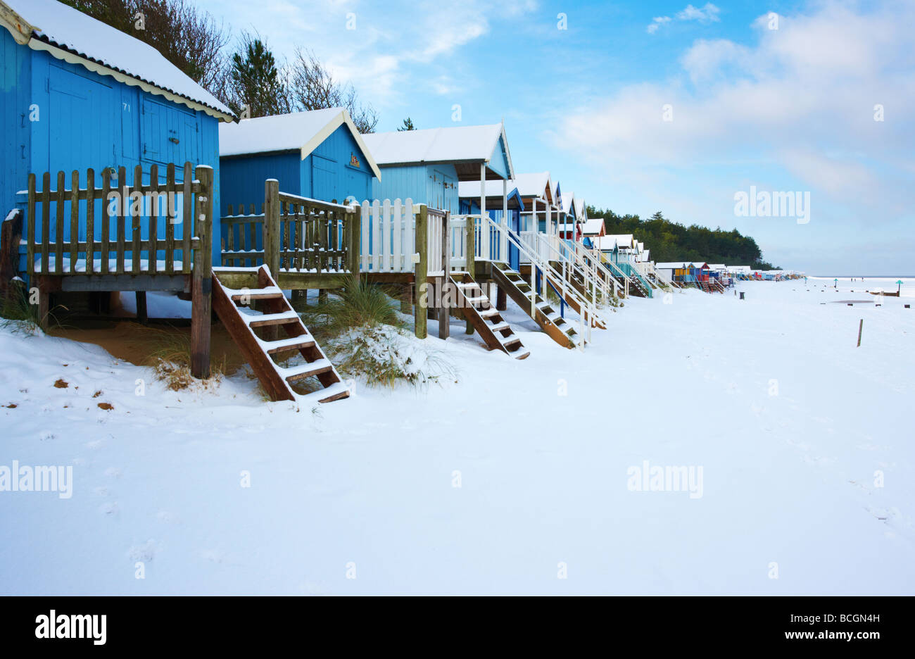 Cabines de plage dans la neige dans des puits à côté de la mer sur la côte nord du comté de Norfolk Banque D'Images