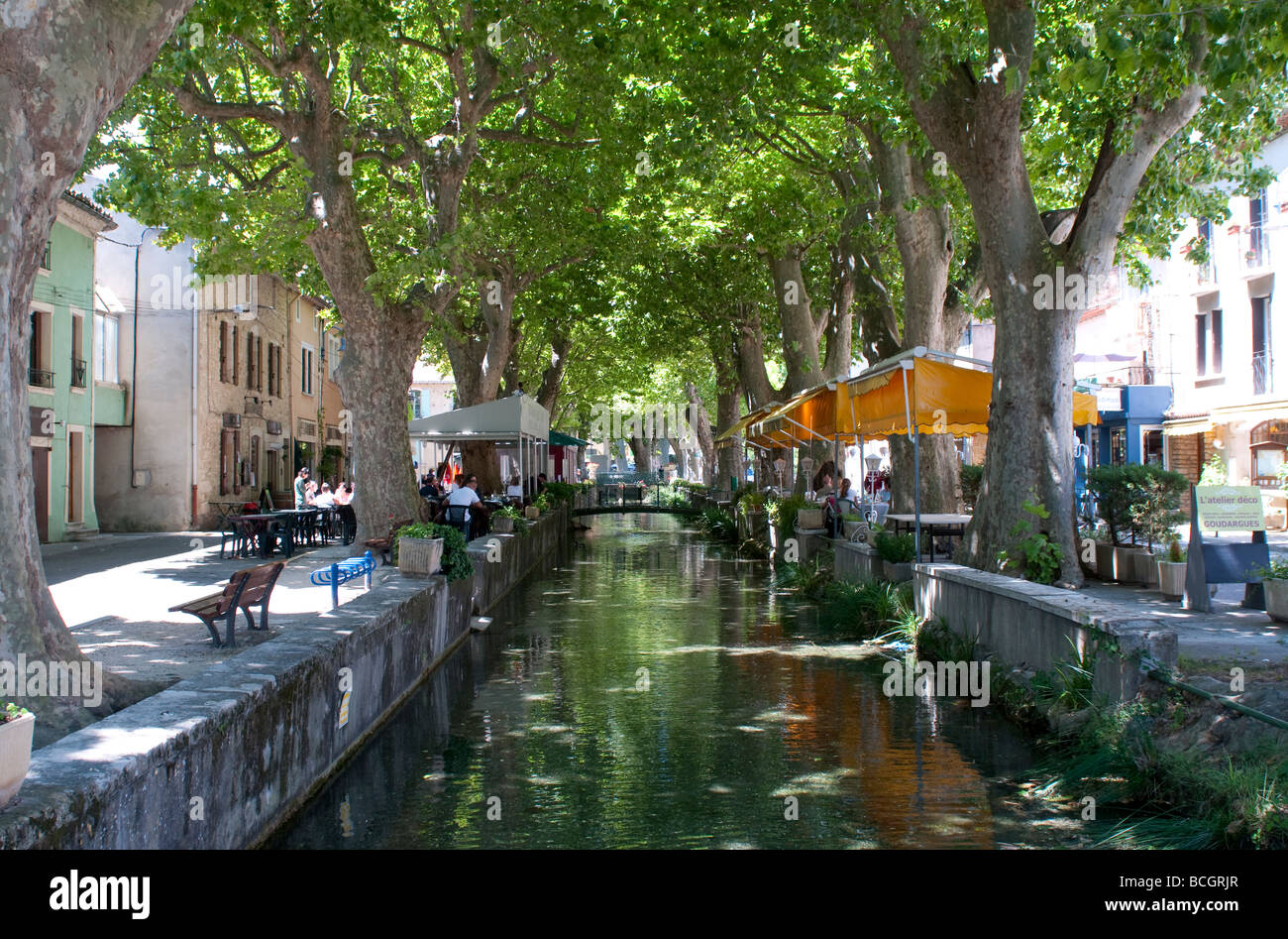 Canal bordé de restaurants et cafés à Goudargues Languedoc France Banque D'Images
