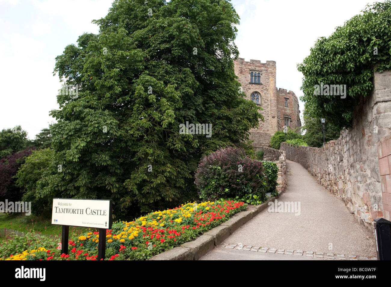 Sentier menant jusqu'à Tamworth Castle en Angleterre avec panneau d'emplacement à côté du lit de fleur en chemin Banque D'Images