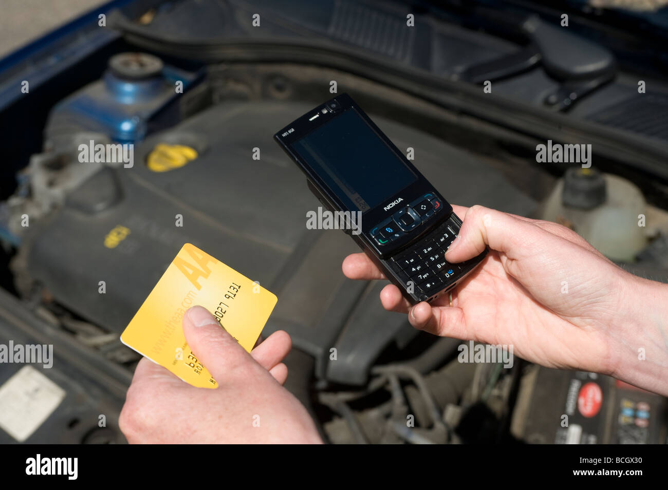 Close up de quelqu'un à l'aide d'un téléphone portable sonne l'aa automobile association à la suite d'une panne de voiture Banque D'Images