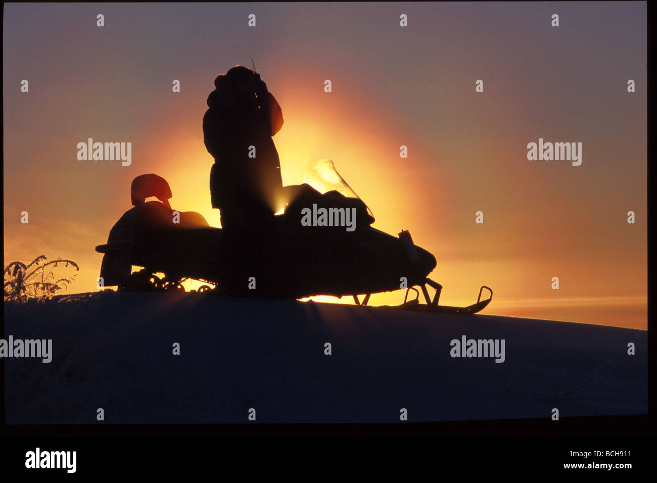 L'homme sur l'aide de motoneiges Cell Phone Kotzebue Western AK winter scenic Banque D'Images