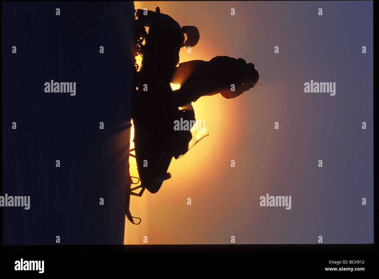 L'homme sur l'aide de motoneiges Cell Phone Kotzebue Western AK winter scenic Banque D'Images