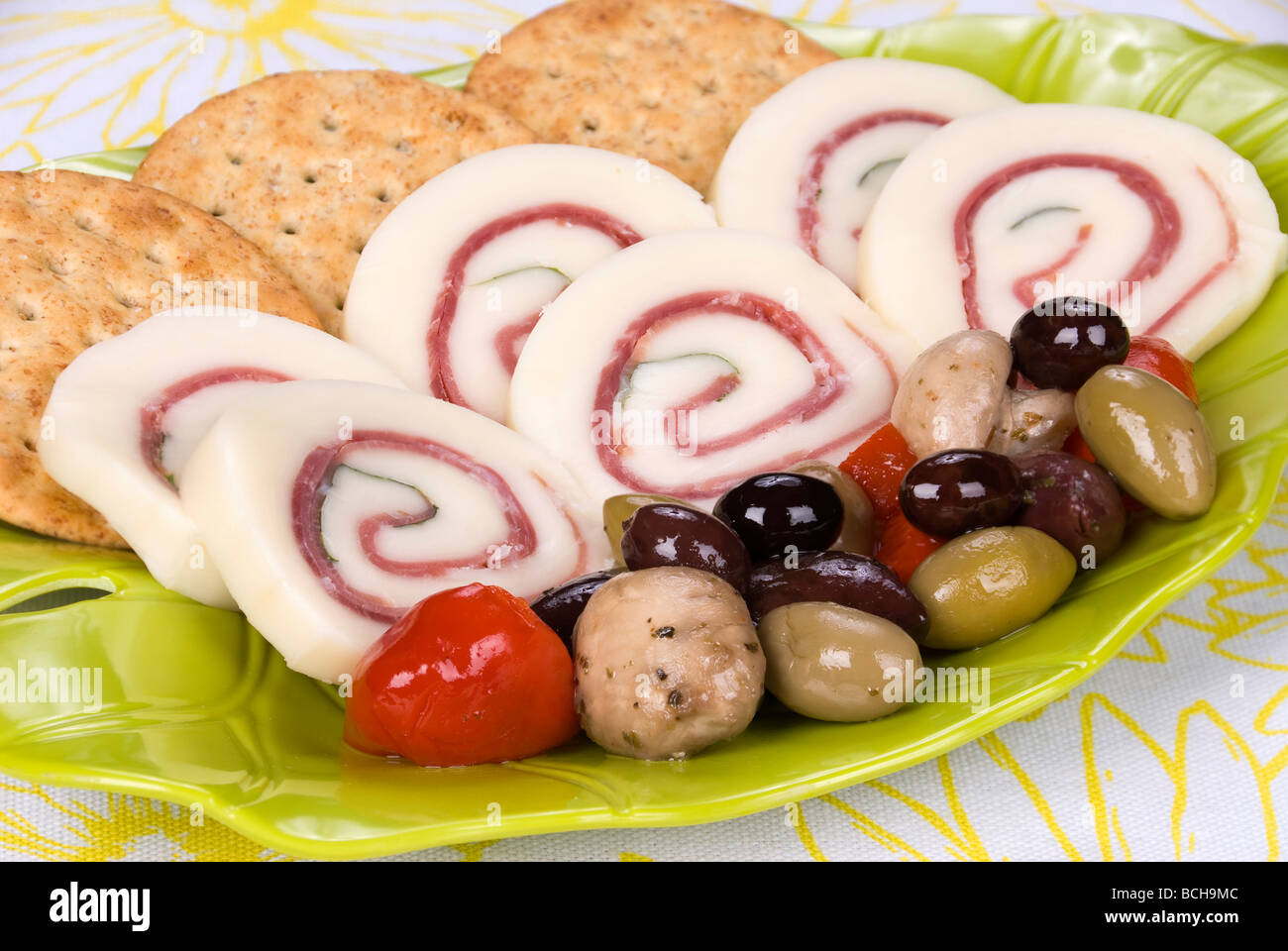 Une plaque snack délicieux de prosciutto au basilic jambon fromage rouleaux avec un assortiment d'olive et les craquelins Banque D'Images