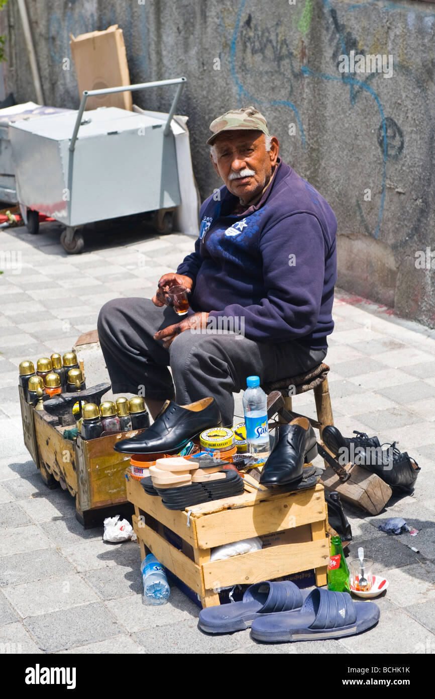 La Turquie , Istanbul , nouvelle mosquée Yeni Cami , ou vieilles chaussures cirées homme attendre derrière personnalisé support en bois pour nettoyer et polir les chaussures Banque D'Images