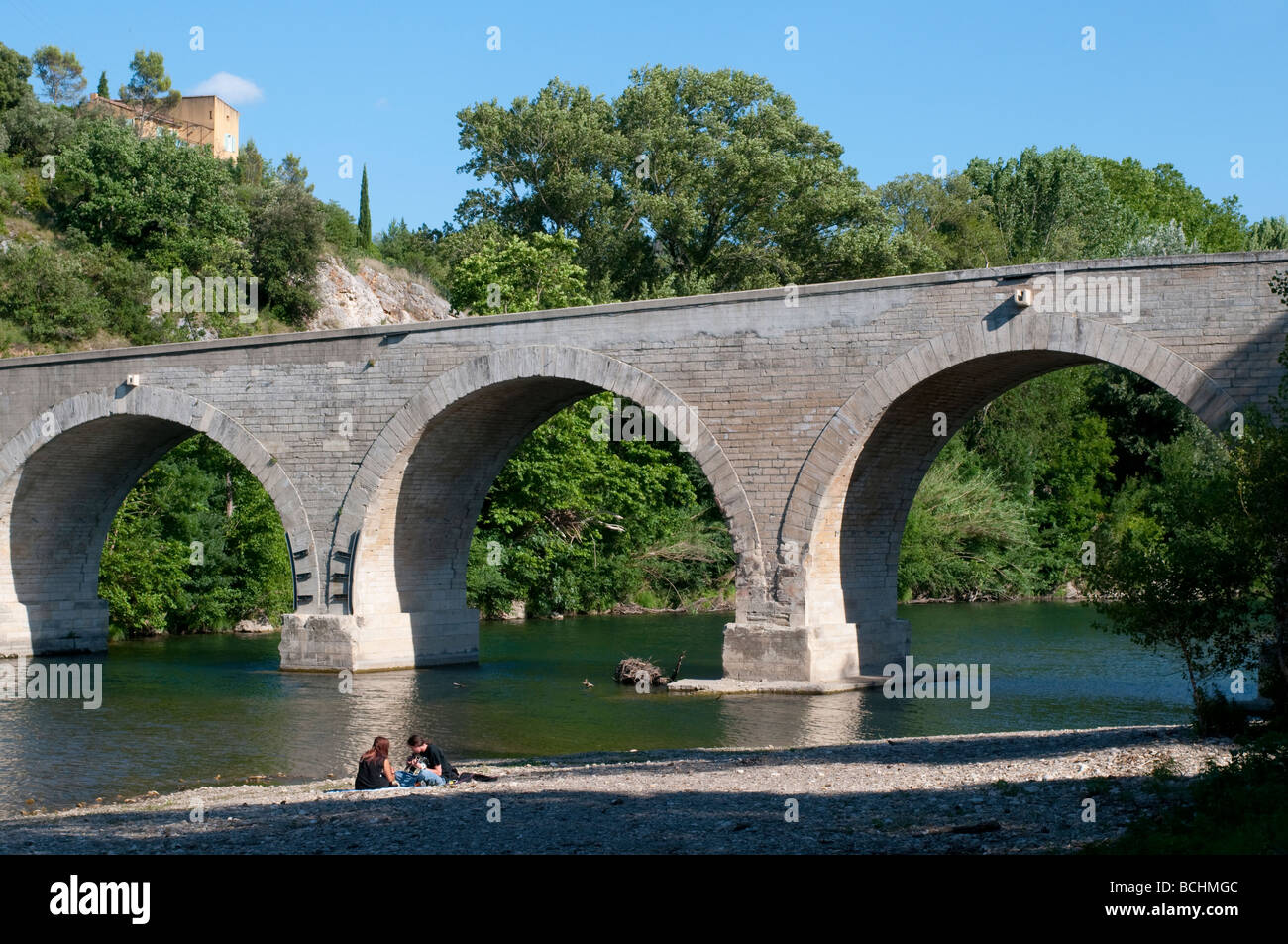 Couple à la guitare près du pont sur la rivière Cèze Languedoc France Banque D'Images