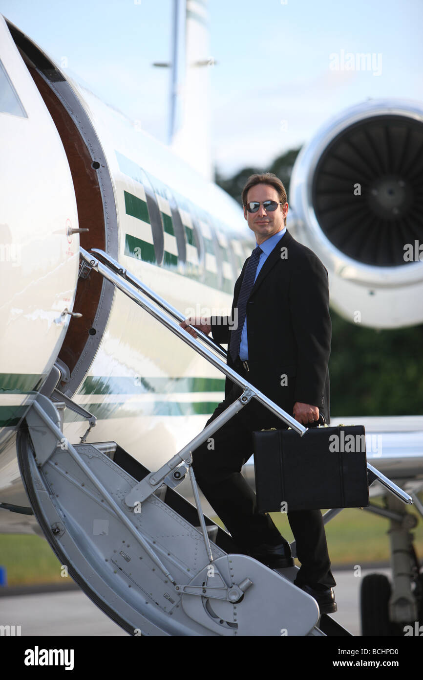 Businessman standing on stairs à Private Jet Banque D'Images